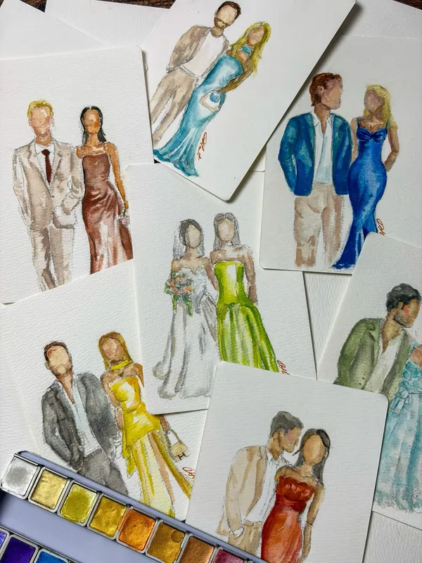 Faceless watercolour fashion sketches of wedding guest couples on cards beside a paint palette, by Darcy Hart