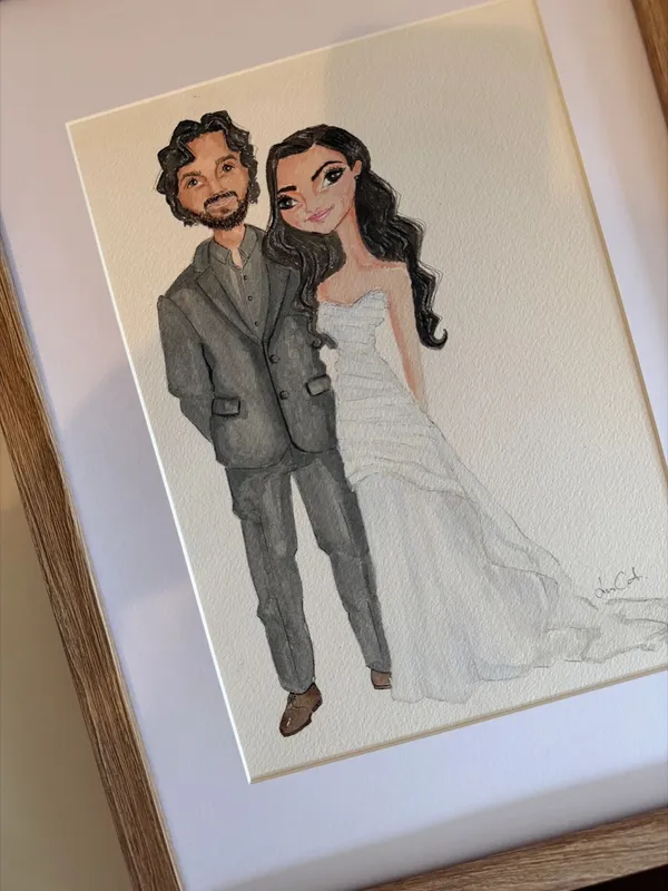 Framed watercolour illustration of a bride and groom in a strapless gown and grey suit, by Lisa Catanea