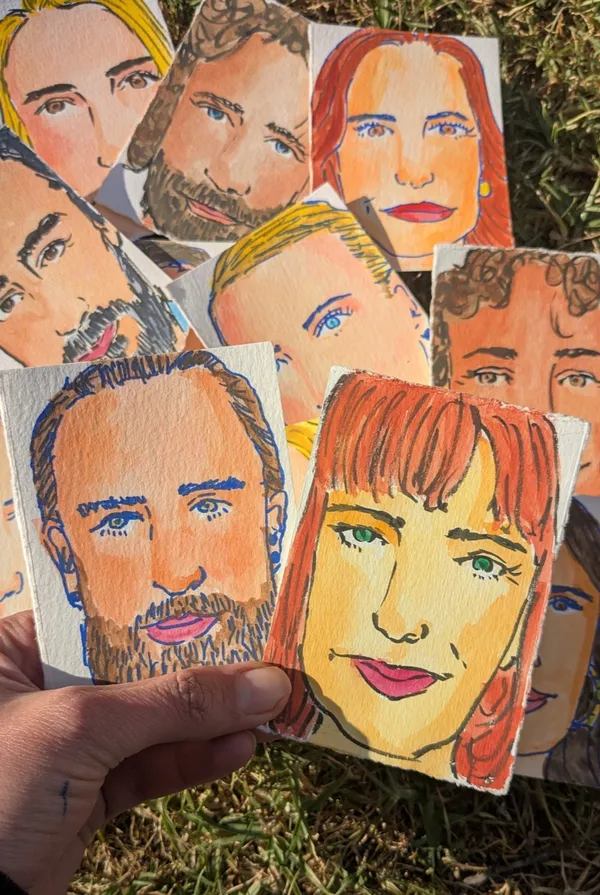 Colourful watercolour and ink face portraits of wedding guests fanned out in hand by Make Art with Miranda